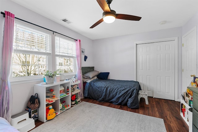 bedroom featuring dark hardwood / wood-style floors, ceiling fan, and a closet