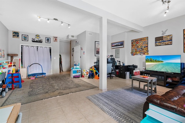 living room with light tile patterned flooring, track lighting, and electric panel