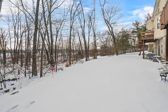 yard covered in snow with a deck