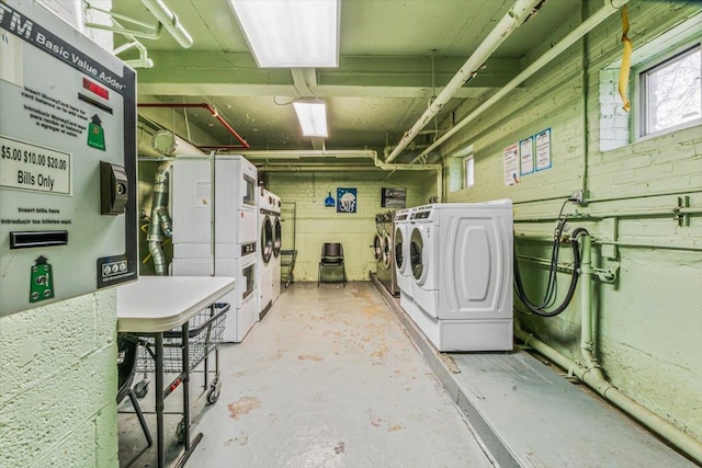 basement featuring washing machine and clothes dryer and stacked washing maching and dryer