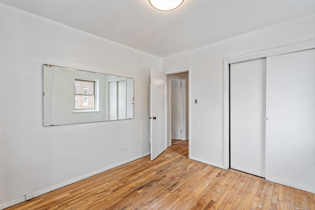 unfurnished bedroom with light hardwood / wood-style floors and a closet