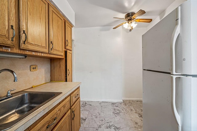 kitchen with white refrigerator, sink, and ceiling fan