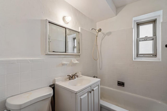 full bathroom featuring tiled shower / bath, vanity, toilet, and tile walls