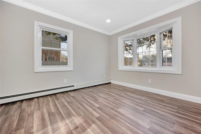 empty room featuring light hardwood / wood-style floors, baseboard heating, a wealth of natural light, and ornamental molding