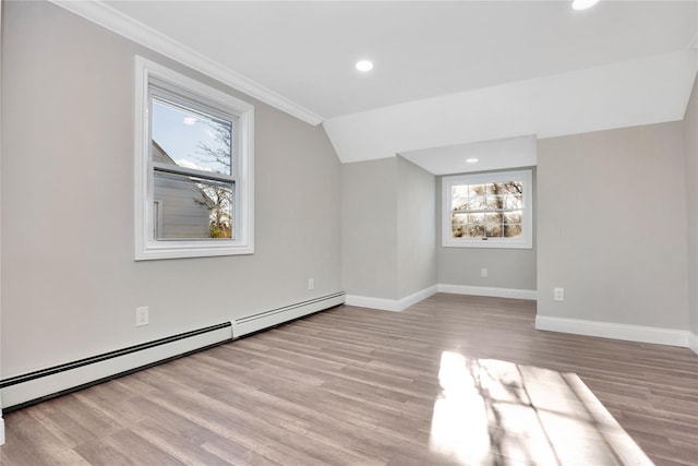 additional living space with lofted ceiling, light hardwood / wood-style flooring, and baseboard heating