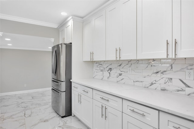 kitchen featuring light stone countertops, white cabinets, decorative backsplash, crown molding, and stainless steel refrigerator