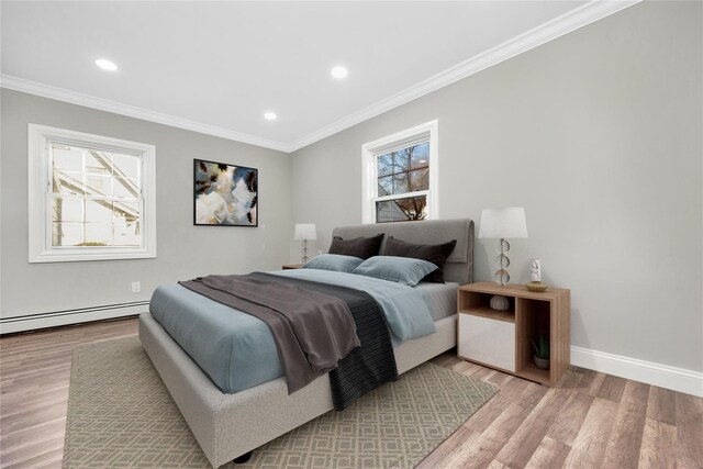 bedroom featuring light hardwood / wood-style flooring, crown molding, and multiple windows