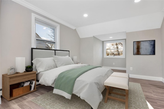 bedroom featuring hardwood / wood-style flooring, ornamental molding, multiple windows, and lofted ceiling