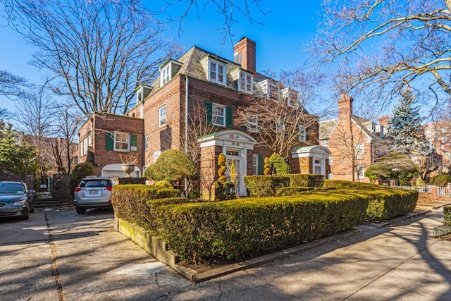 view of front of home featuring brick siding and a chimney