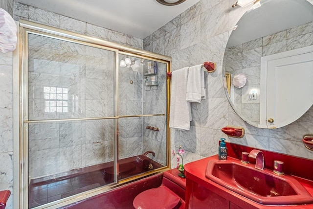 full bath featuring backsplash, combined bath / shower with glass door, tile walls, and vanity