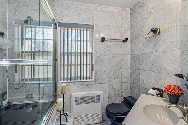 full bath featuring radiator, tile walls, an enclosed shower, and toilet