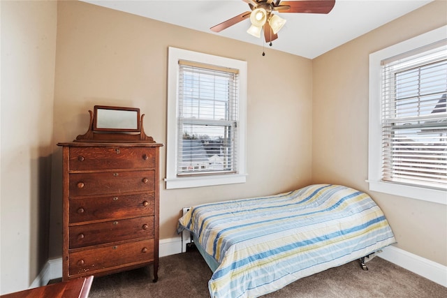 bedroom featuring baseboards, multiple windows, and dark carpet