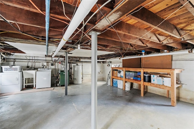 unfinished basement with water heater, a heating unit, a sink, and independent washer and dryer