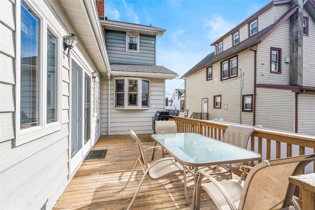 deck featuring visible vents and outdoor dining area