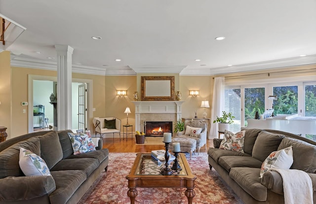 living room with ornate columns, wood-type flooring, and crown molding