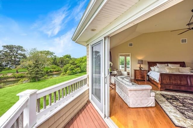 bedroom with vaulted ceiling, access to outside, and hardwood / wood-style floors