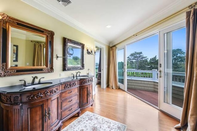 bathroom with vanity, wood-type flooring, a chandelier, and crown molding