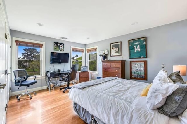 bedroom featuring multiple windows and light wood-type flooring