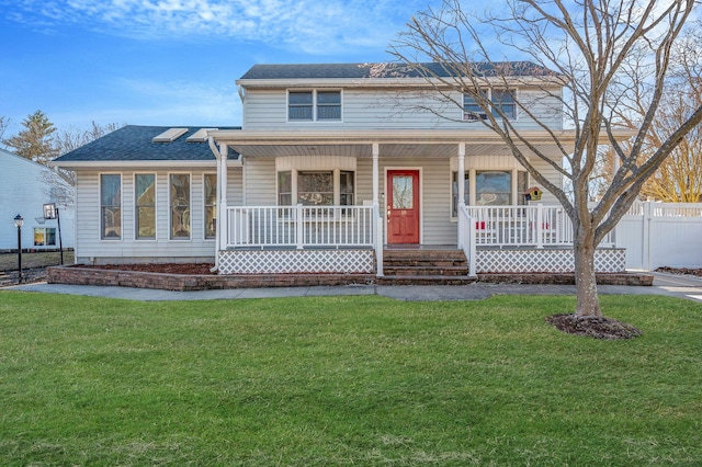 view of front facade featuring roof with shingles, covered porch, a front lawn, and fence