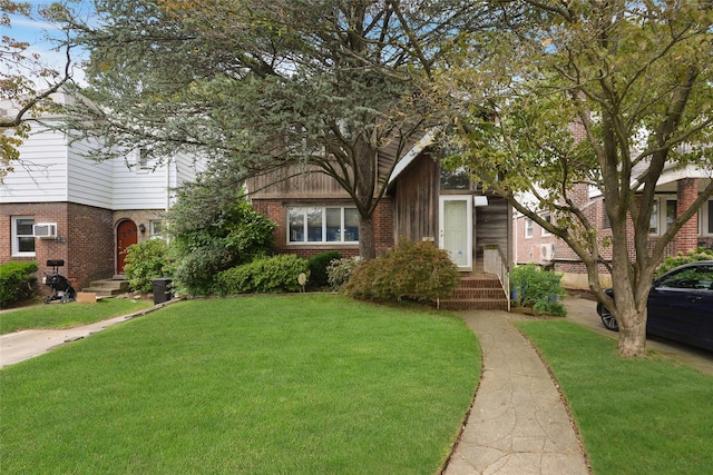 view of front facade with a front lawn and an AC wall unit