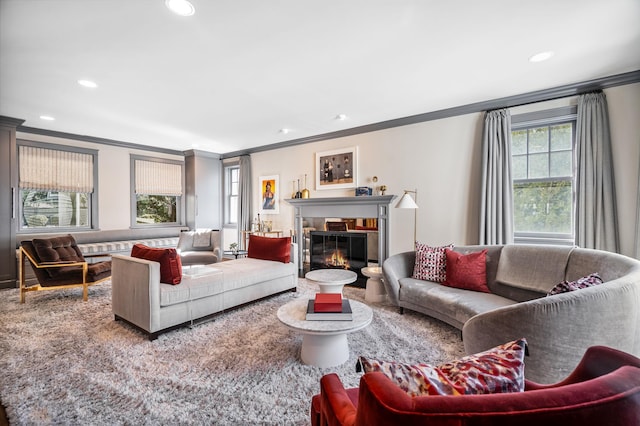 living area featuring recessed lighting, ornamental molding, and a glass covered fireplace