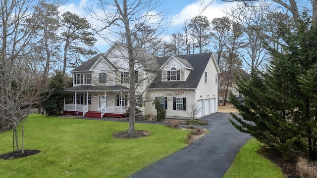 view of front of house with a garage, a front yard, and covered porch