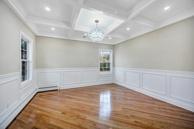 unfurnished room featuring coffered ceiling, a chandelier, beamed ceiling, hardwood / wood-style floors, and a baseboard heating unit