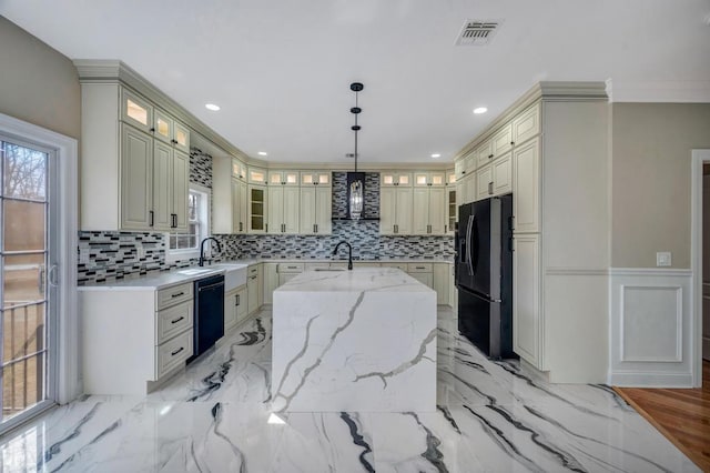 kitchen featuring sink, light stone counters, hanging light fixtures, a kitchen island with sink, and black appliances