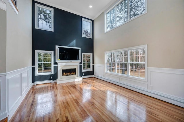 unfurnished living room featuring wood-type flooring and baseboard heating