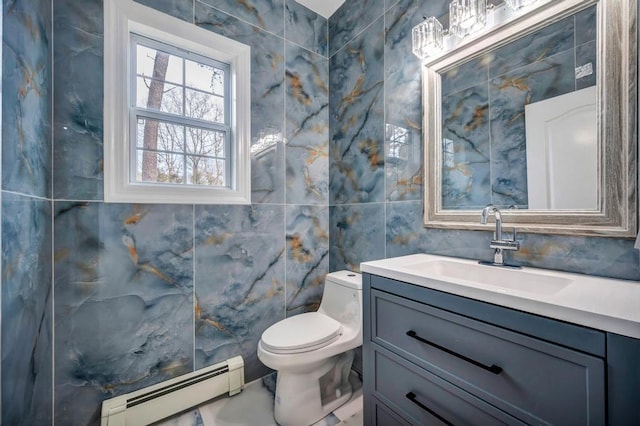 bathroom featuring vanity, toilet, tile walls, and a baseboard heating unit