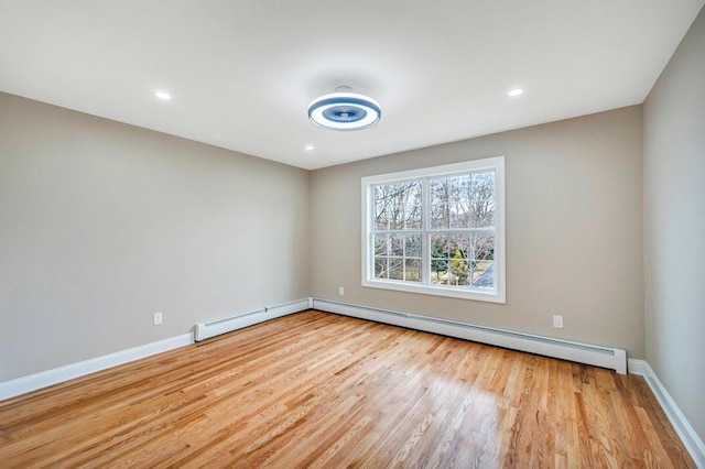 empty room featuring light hardwood / wood-style floors and baseboard heating