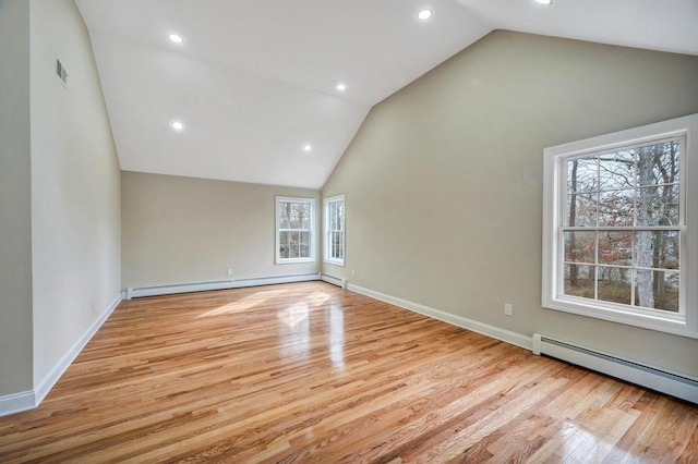 unfurnished room with a baseboard radiator, lofted ceiling, and light hardwood / wood-style flooring