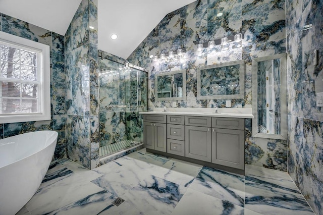 bathroom featuring independent shower and bath, vaulted ceiling, tile walls, and vanity