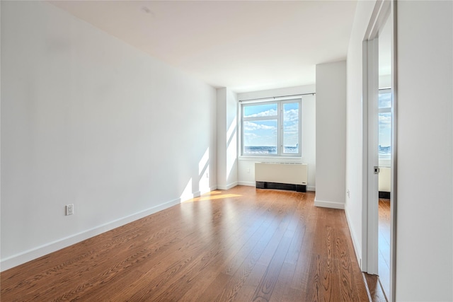 spare room with hardwood / wood-style flooring and radiator heating unit