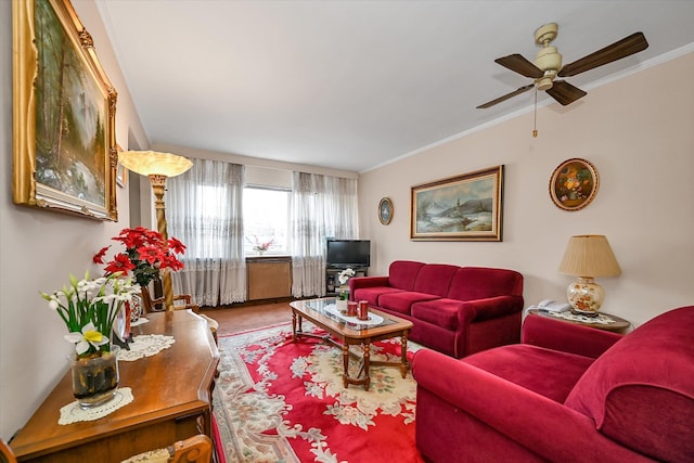 living room with ornamental molding and ceiling fan