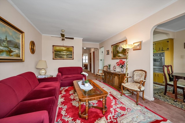 living room with ceiling fan, ornamental molding, and carpet floors