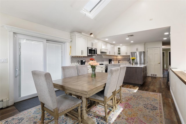 dining room featuring high vaulted ceiling, a skylight, dark wood finished floors, and visible vents