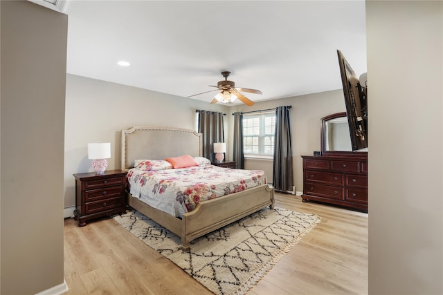 bedroom featuring baseboards, ceiling fan, a baseboard heating unit, and light wood-style floors