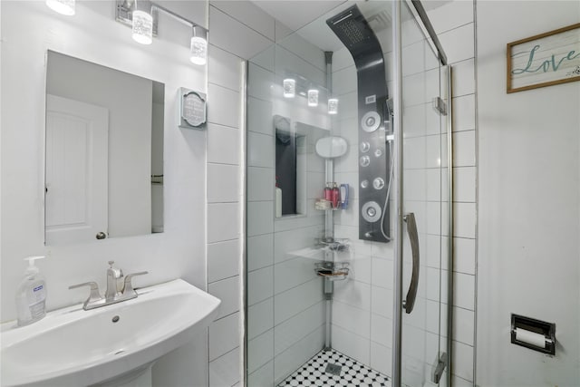 bathroom featuring a stall shower and a sink