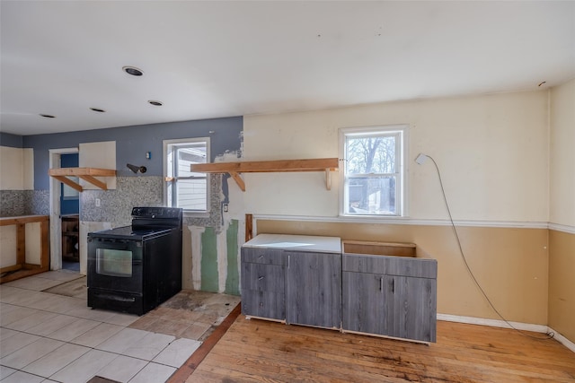 kitchen with black / electric stove and light wood-type flooring