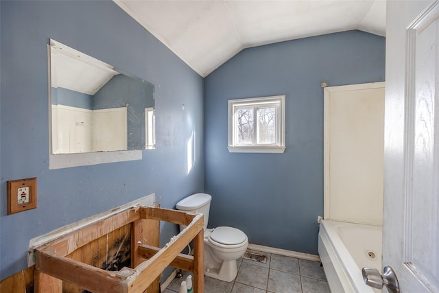 bathroom with vaulted ceiling, a washtub, tile patterned floors, and toilet