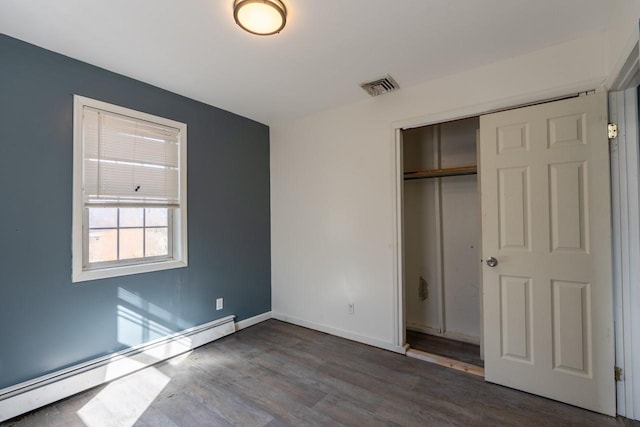 34 Laurel Trl, Monroe, NY 10950 - unfurnished bedroom featuring visible vents, baseboards, a closet, baseboard heating, and wood finished floors