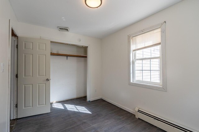 34 Laurel Trl, Monroe, NY 10950 - unfurnished bedroom featuring baseboard heating, baseboards, a closet, visible vents, and wood finished floors
