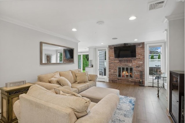 living room featuring ornamental molding, visible vents, and plenty of natural light