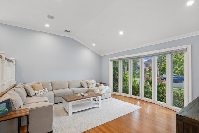 living room with vaulted ceiling, ornamental molding, recessed lighting, and light wood-style floors