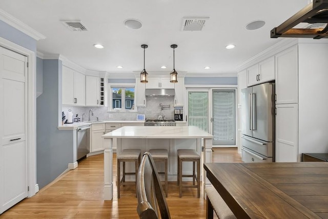 kitchen featuring visible vents, white cabinets, appliances with stainless steel finishes, decorative light fixtures, and light countertops