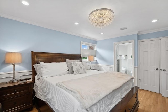 bedroom with crown molding, recessed lighting, light wood-style floors, wainscoting, and connected bathroom