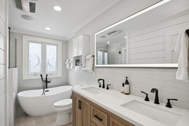 full bath featuring ornamental molding, a soaking tub, visible vents, and a sink