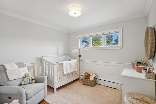 bedroom with a nursery area, a wainscoted wall, a baseboard radiator, and crown molding