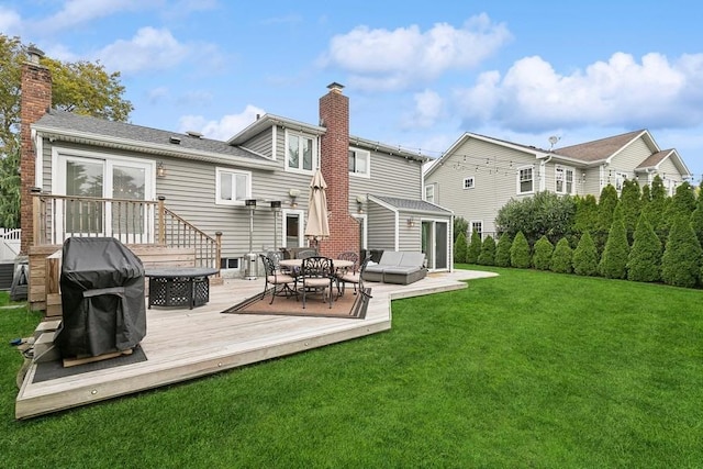 rear view of property with a fire pit, a yard, a chimney, and a wooden deck